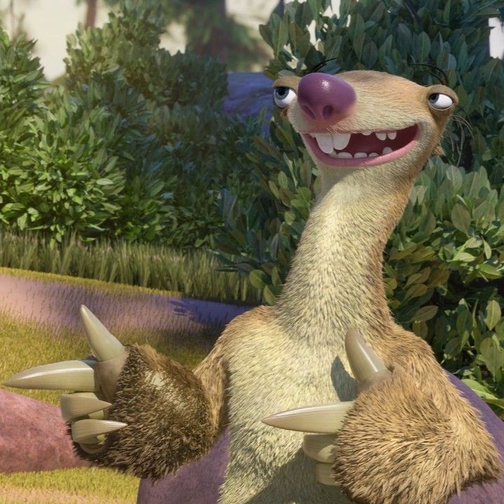 an animated animal with large horns and big teeth sitting on the ground in front of some bushes