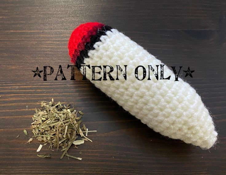 a crocheted object sitting on top of a wooden table next to a pile of dried herbs