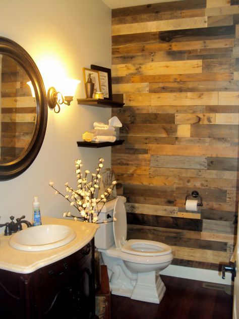 the bathroom is decorated with wood planks on the wall, and has a white toilet