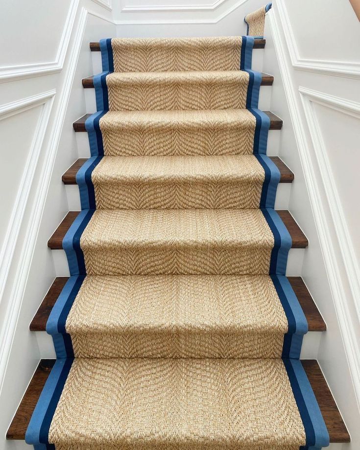 a blue and brown carpeted staircase leading up to the second floor in a home