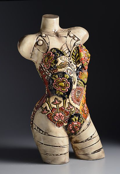 a ceramic sculpture of a woman's torso with flowers on it