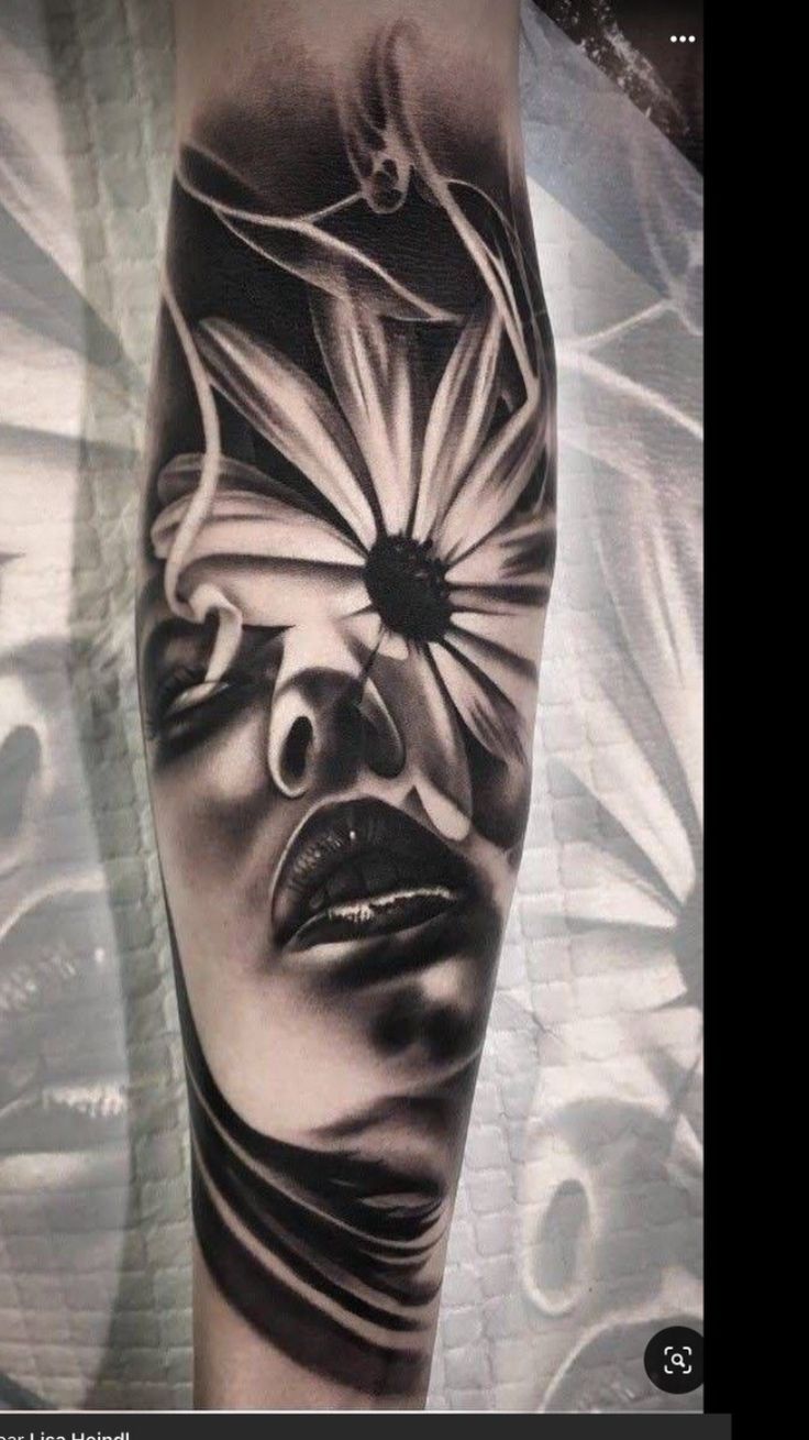 a black and white tattoo with a woman's face in the middle of it