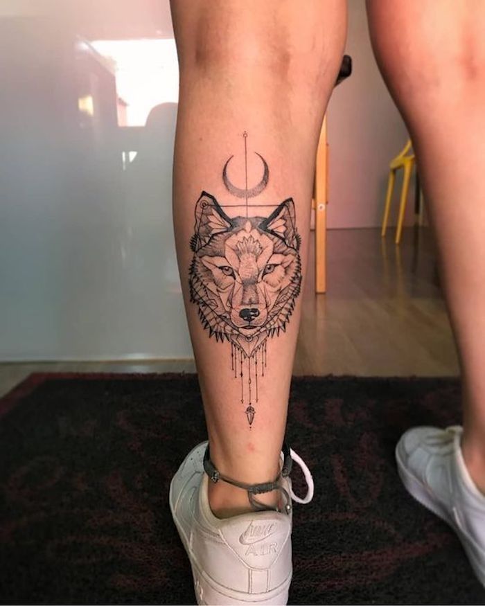 a person with a wolf tattoo on their leg