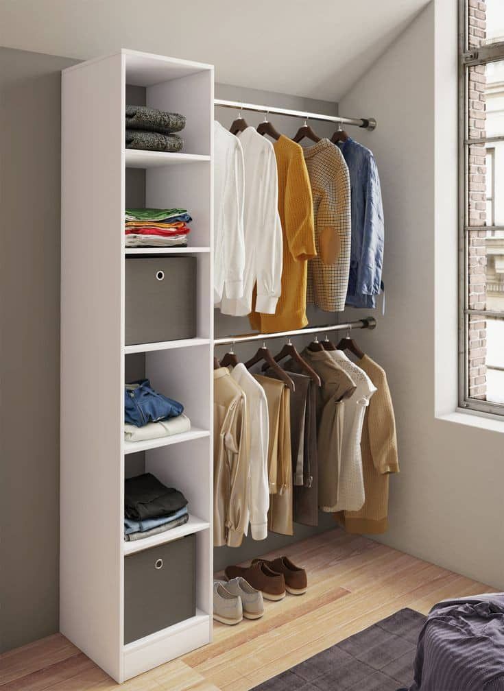 a closet with clothes and shoes hanging on the wall next to a bed in front of a window