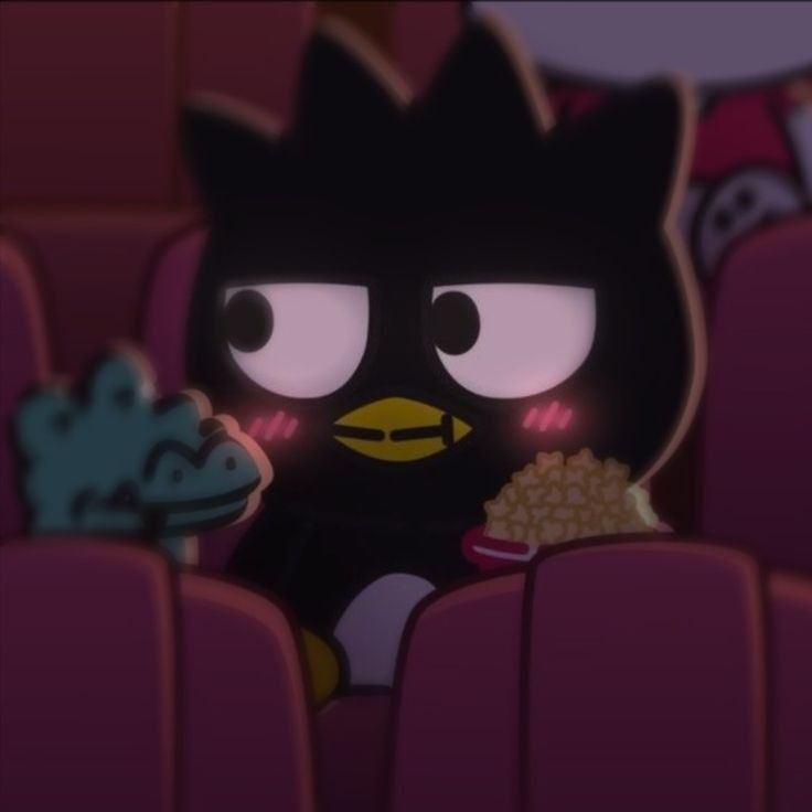 a black cat sitting in the middle of a movie theater