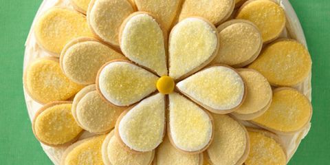 an overhead view of some cookies with yellow flowers on them and white icing in the middle