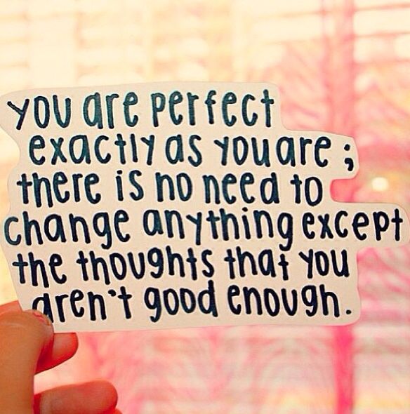 someone holding up a piece of paper that says, you are perfect exactly as you are there is no need to change anything except the thoughts that you aren't good enough