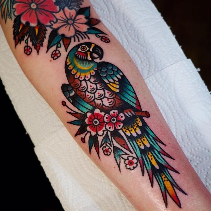 a colorful bird tattoo on the arm