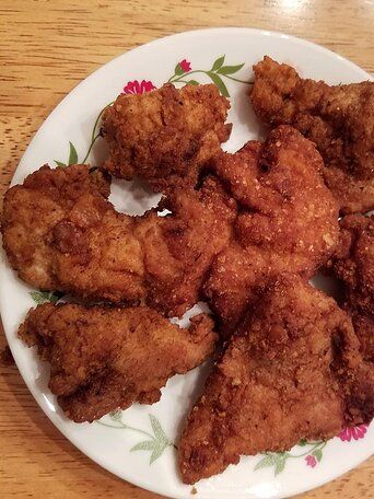 fried chicken pieces on a plate sitting on a table