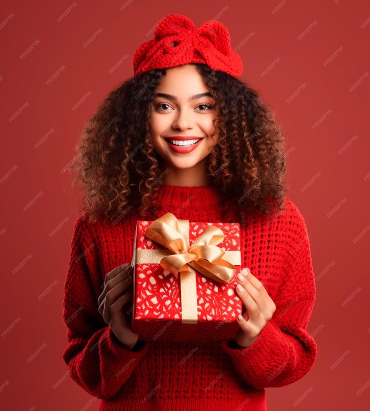 a woman in a red sweater is holding a present box with a bow on it