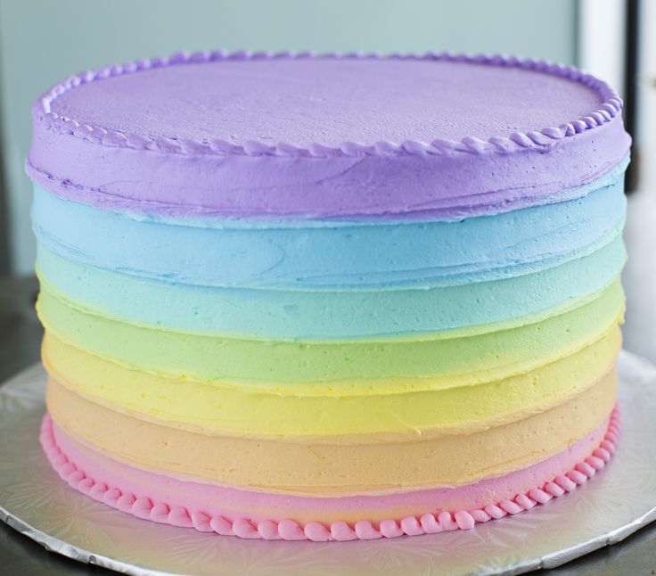 a multi colored cake with frosting on top