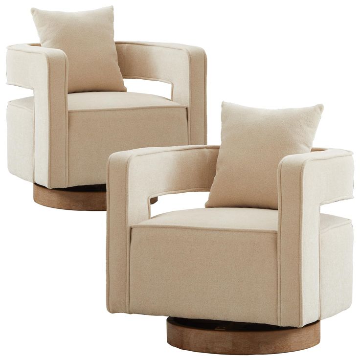 two beige chairs with pillows on them sitting side by side in front of each other