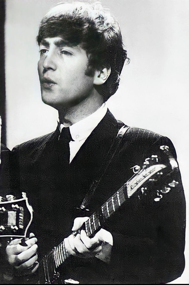 a man holding a guitar in his right hand