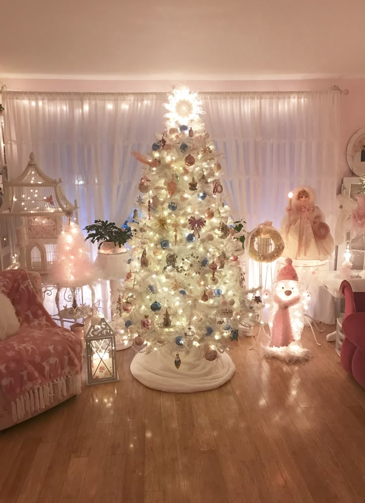 a white christmas tree in a living room decorated with pink and gold ornaments, surrounded by other holiday decorations