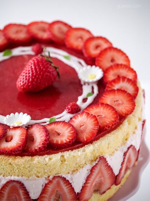 a cake with strawberries on top and white icing around the edges is shown