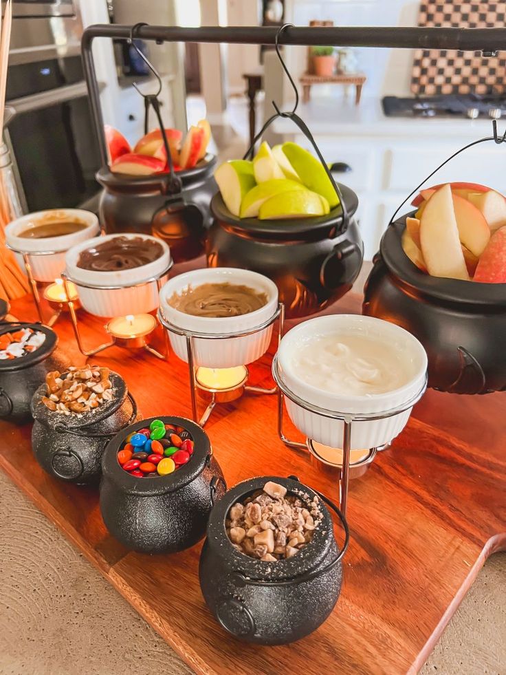 a wooden table topped with bowls filled with different types of desserts and candies