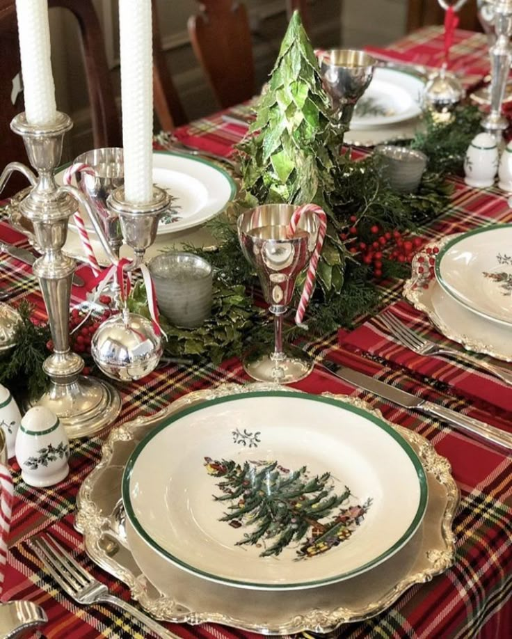 the table is set for christmas dinner with plates and silverware