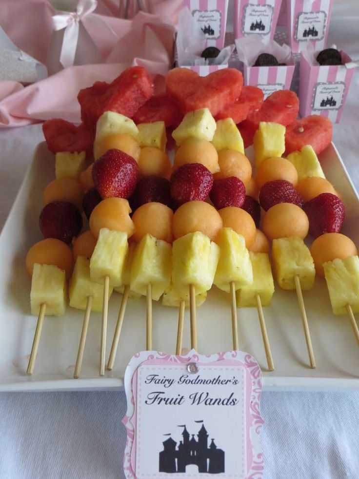 fruit skewers are arranged on a white plate