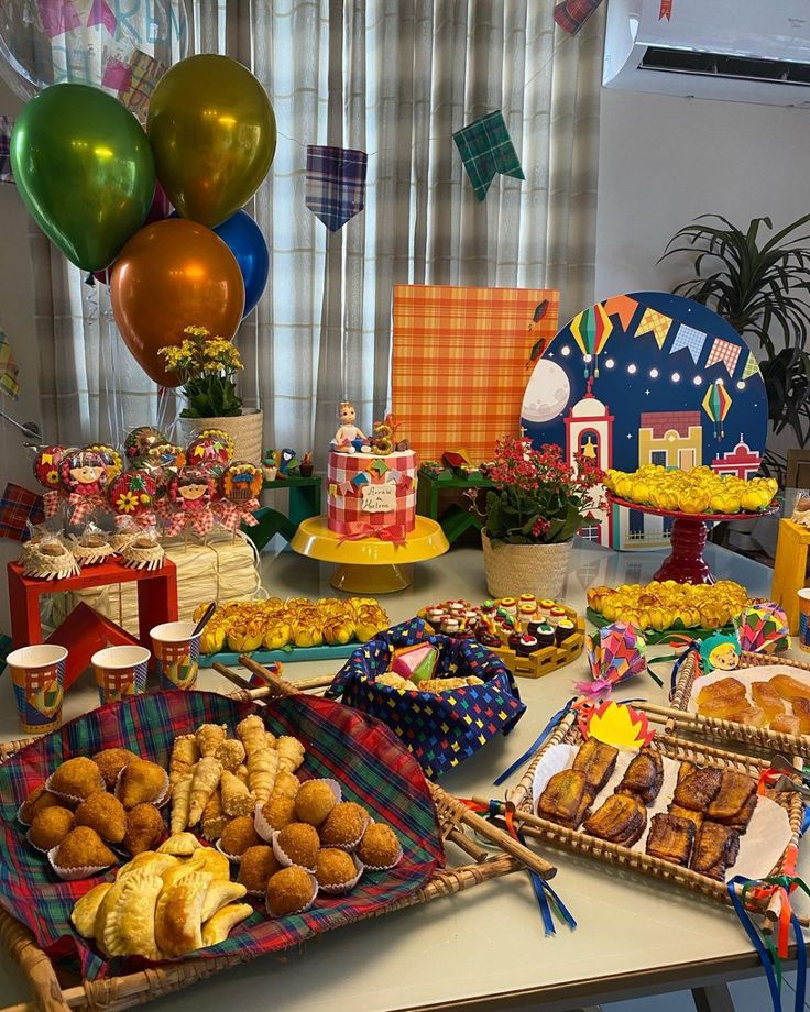 a table filled with lots of food and balloons