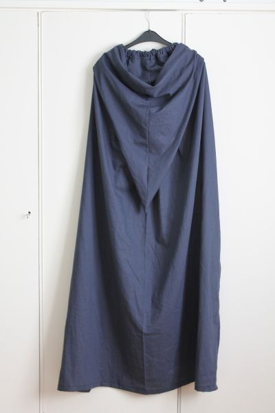 a blue coat hanging on a white wall