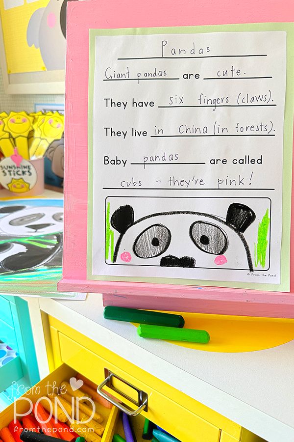 a child's hand holding up a paper with writing on it in front of other children's toys