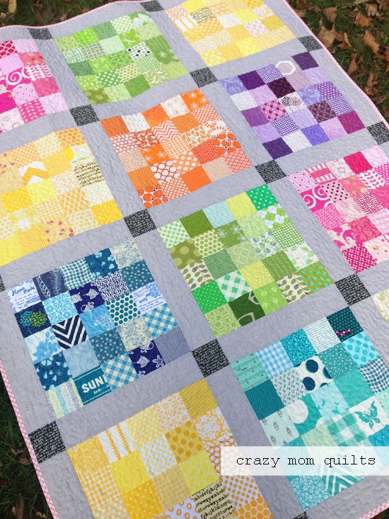 a colorful quilt on the grass with words crazy mom quilts written in front of it