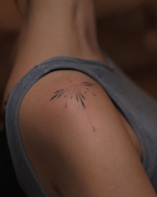 the back of a woman's shoulder with a small tattoo on her left arm