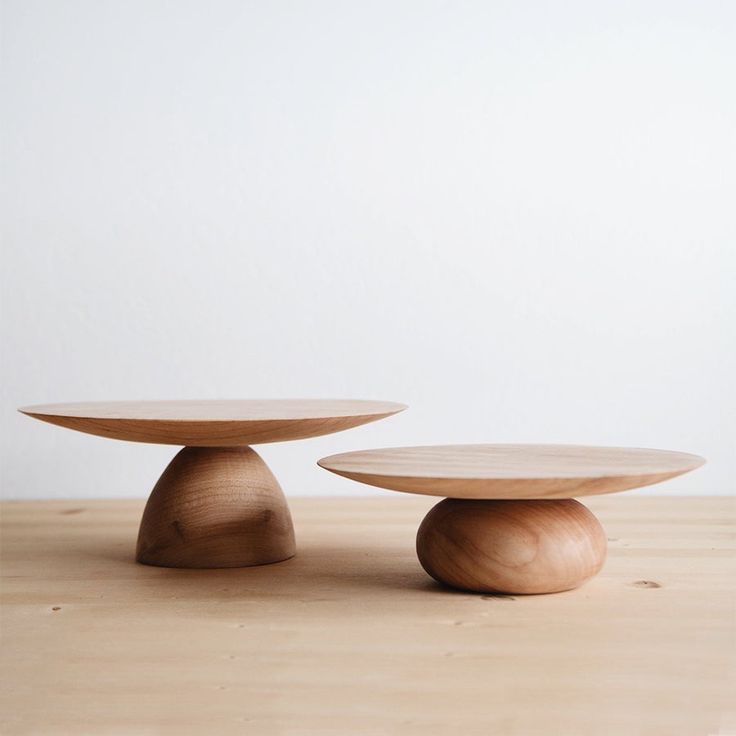 two wooden tables sitting on top of a wooden table