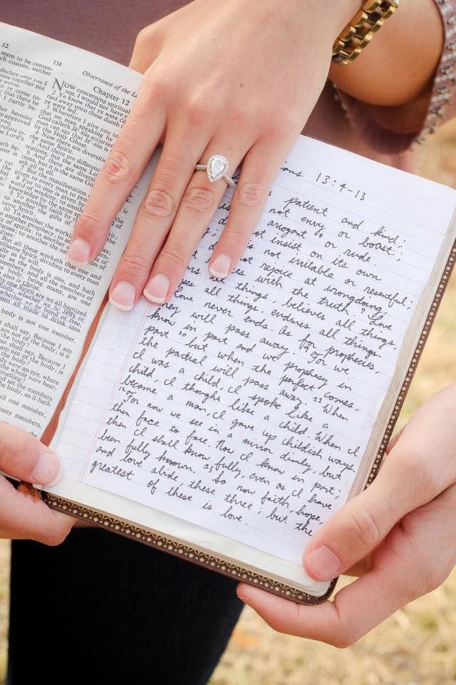 two people holding an open book with writing on it and one person's wedding ring