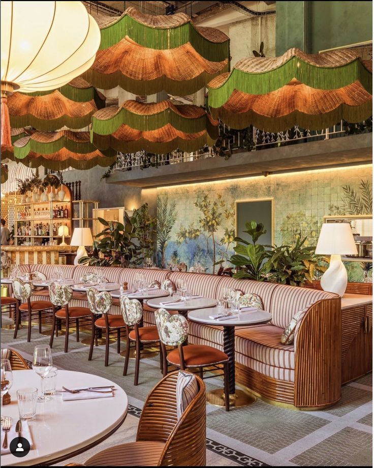 the interior of a restaurant with tables, chairs and umbrellas hanging from the ceiling