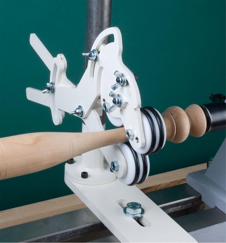 a close up of a baseball bat on a machine with a green wall in the background