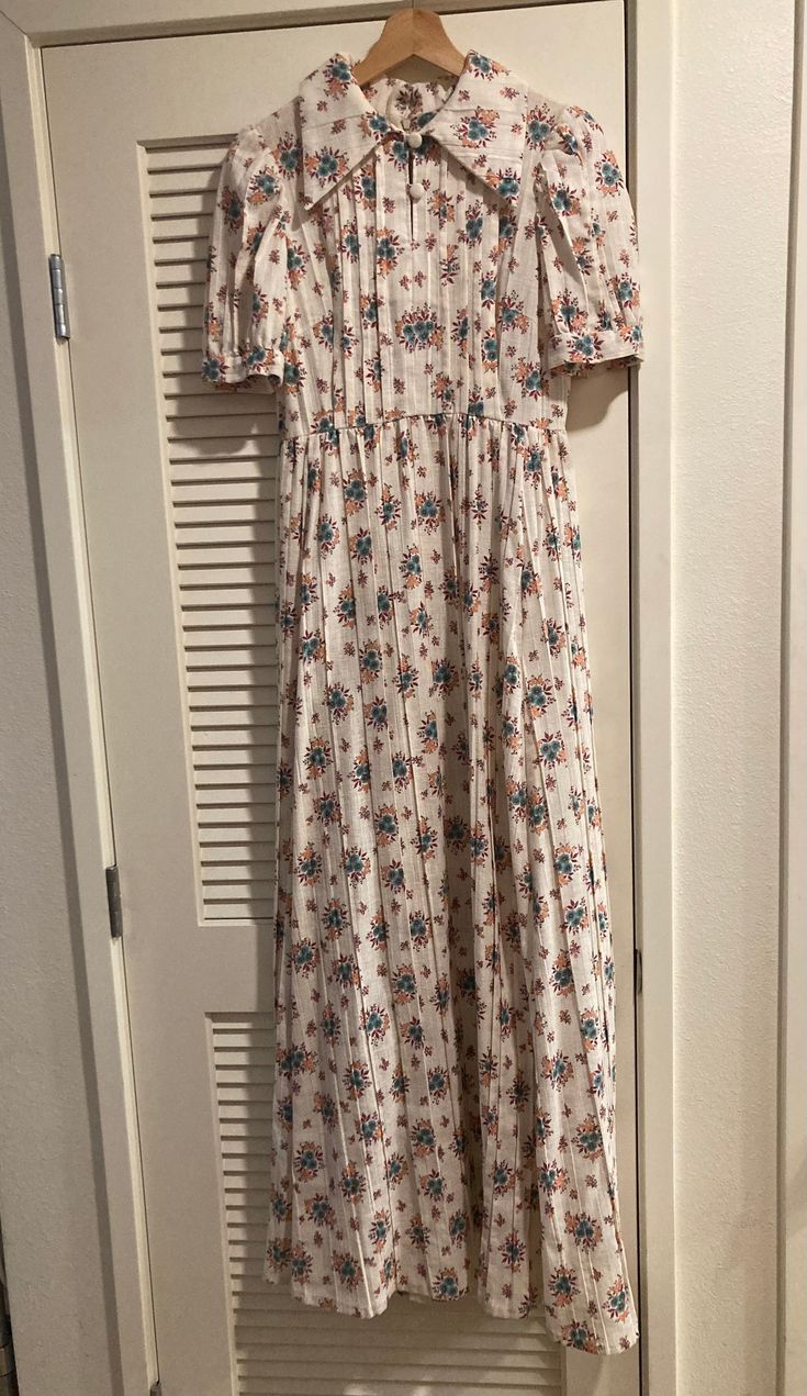 Handmade 1970's floral maxi dress. This dress is in good vintage condition with minor marks and discoloration. The dress has two functional buttons on the front and a zipper in the back. There is no tag, but the material has no stretch and feels like a linen or synthetic mix.   Color: Cream with a blue, orange, red floral pattern. The dress fits like a small/medium Measurements are approximate Waist: 14" Should to shoulder 14" Length from shoulder to hem: 56 1/2"  Keep in mind this dress is vint Ditsy Floral Print Maxi Dress For Daywear, Retro Floral Print Maxi Dress For Daywear, Retro Maxi Dress For Daywear, Retro Daywear Maxi Dress, Retro Floral Print Maxi Dress, Retro Vintage Floral Print Maxi Dress, Red Floral Pattern, Mix Color, Floral Maxi