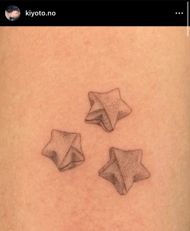 three small stars on the back of a woman's shoulder