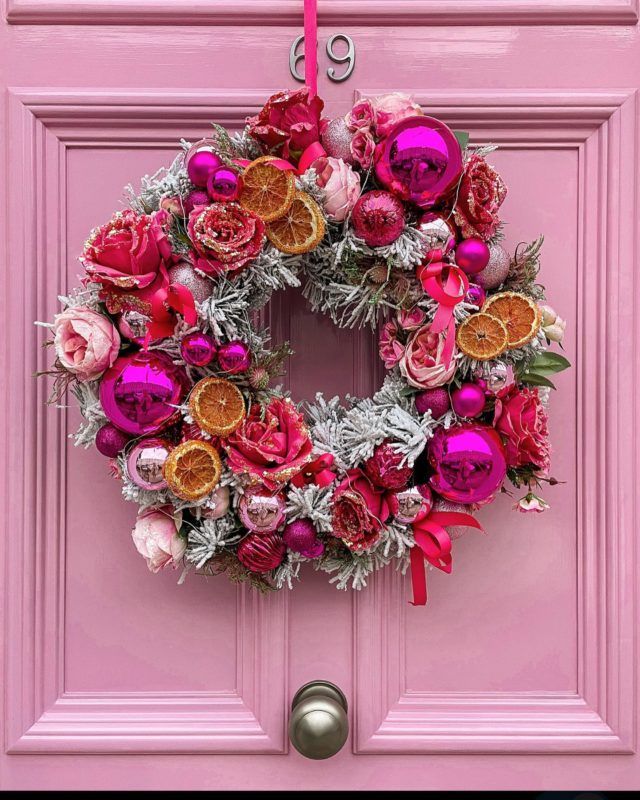 a pink door with a wreath on it