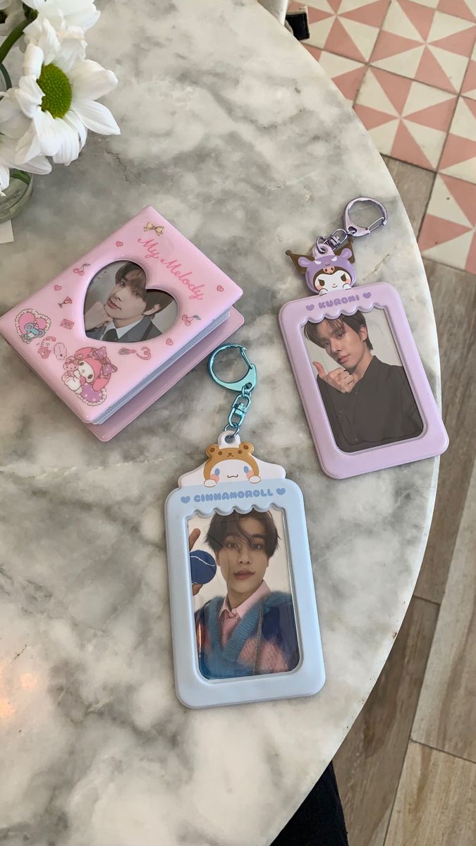 three personalized keychains sitting on top of a marble table next to flowers