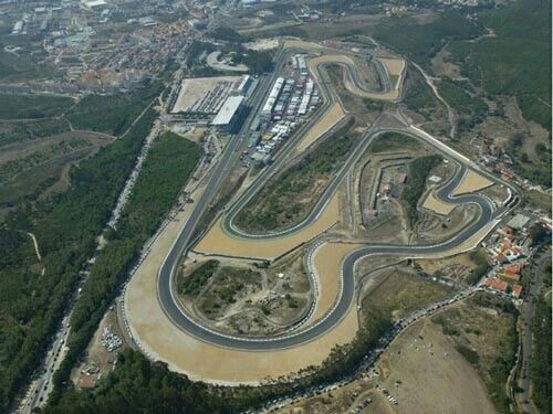 an aerial view of a race track in the middle of a country side town area