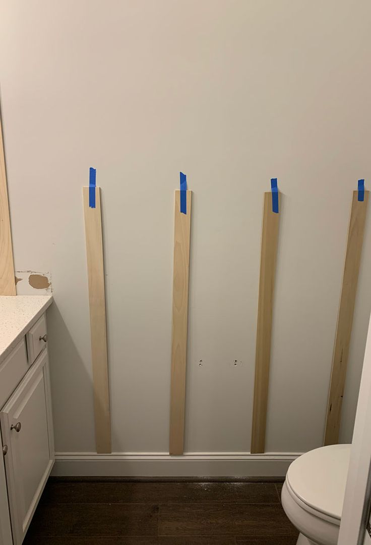 three pieces of wood sticking out of the wall next to a toilet in a bathroom