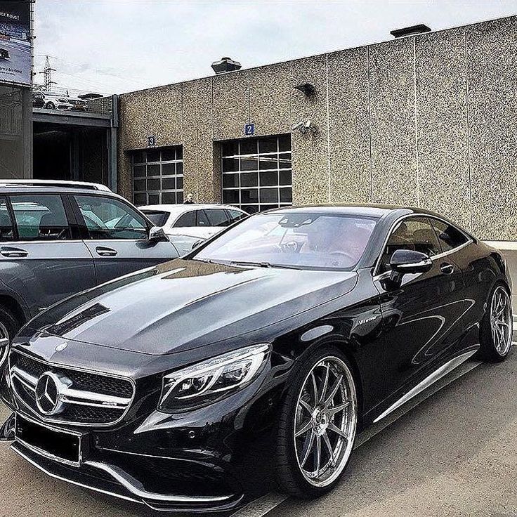 two cars parked next to each other in front of a building