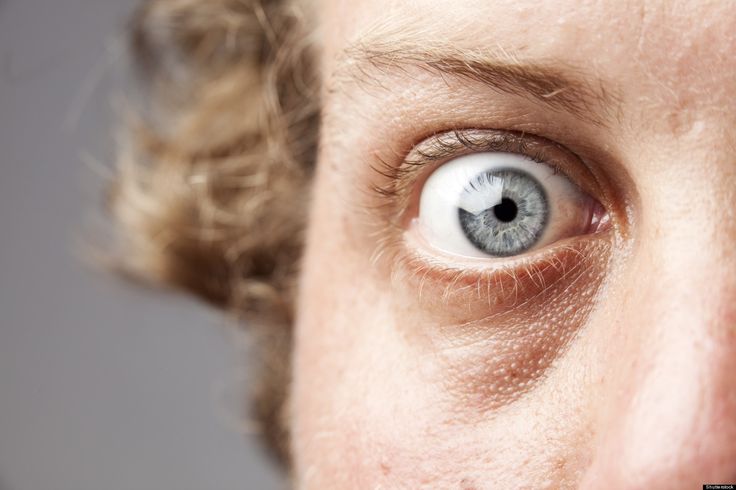 a man's blue eye is seen through the lens