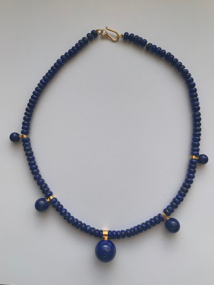 "This necklace is handmade from Lapis Lazuli. These are beautiful quality stones in a rondell shape ( 6mm x 3 mm)  with 5 lapis gem balls 8mm -16mm in size. The necklace is 18 inches long and hand-knotted on gold thread. The clasp is sterling silver plated with 14k gold.  In ancient times Lapis Lazuli was most highly regarded because of its beautiful color and the valuable ultramarine dye and paint color derived from it. Its name comes from the Latin lapis, \"stone,\" and the Persian word \"blue Sapphire Colored Lapis Lazuli Round Bead Jewelry, Sapphire Beaded Necklaces With Natural Lapis Lazuli Stones, Sapphire-colored Lapis Lazuli Round Beaded Jewelry, Traditional Jewelry With Round Lapis Lazuli Beads, Lapis Lazuli Round Beaded Necklaces, Lapis Lazuli Necklace With Polished Round Beads, Lapis Lazuli Necklaces With 8mm Beads, Lapis Lazuli Necklace With 8mm Beads, Blue Lapis Lazuli Necklace With Spacer Beads