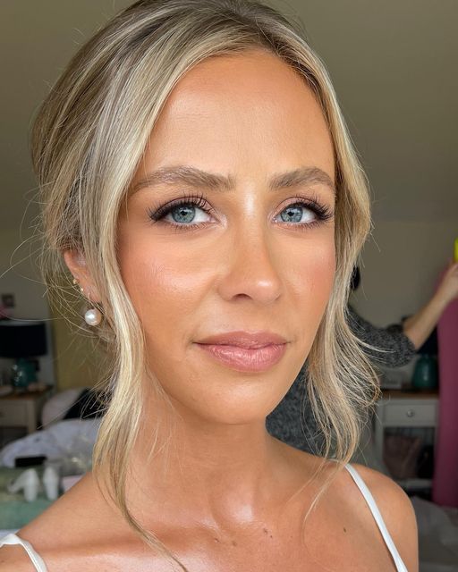 a woman with blonde hair and blue eyes is posing for a photo in her bedroom