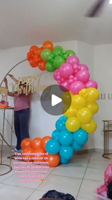 a woman standing next to a bunch of balloons in a room with white tile flooring