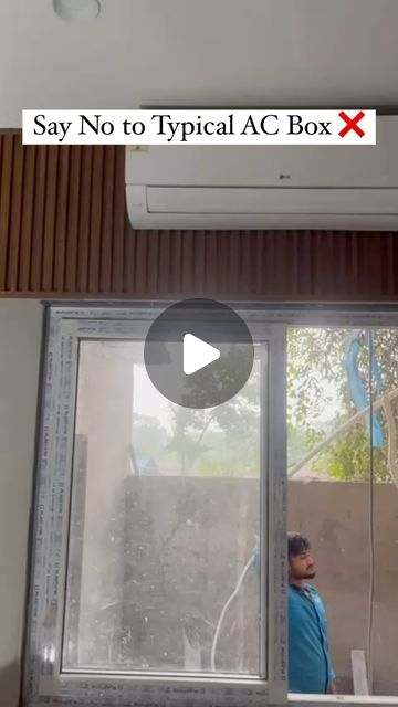 an air conditioner sitting on top of a window sill next to a man