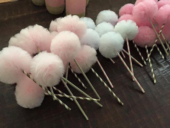 pink and white pom - poms are lined up on the table