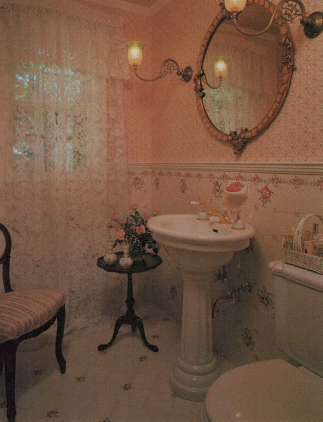 an old fashioned bathroom with floral wallpaper and white fixtures, including a pedestal sink