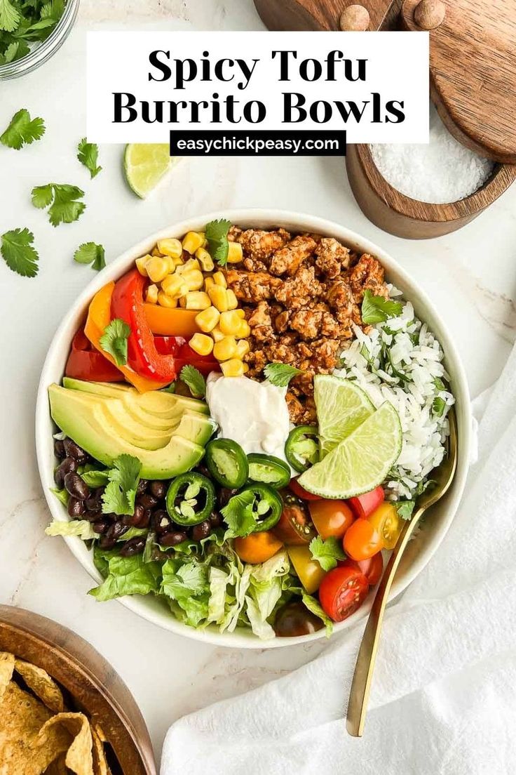 a bowl filled with taco salad next to tortilla chips and avocado