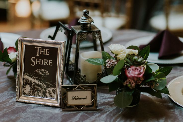 the table is set with flowers, candles and an old - fashioned book on it