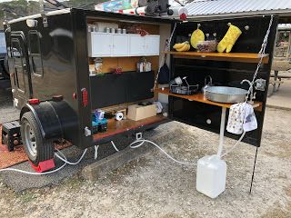 an outdoor bbq with cooking utensils attached to the grill and shelves on the side