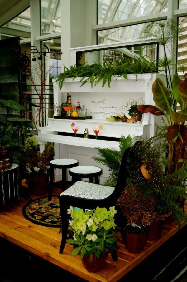 a piano is surrounded by potted plants