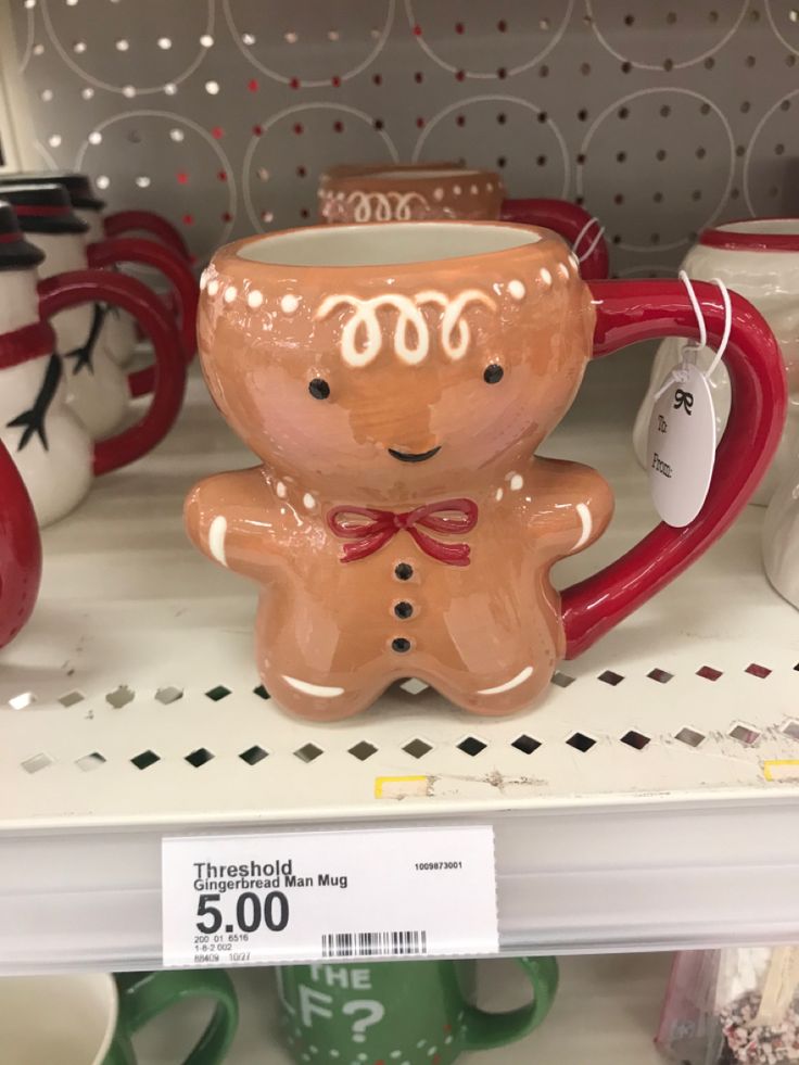 ceramic mugs are on display for sale at the store's shelves, including one with a gingerbread man in a bow tie